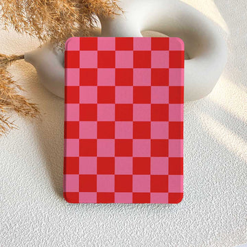 A checkered pattern Kindle case in red and pink, displayed on a white surface.