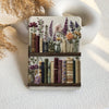 Decorative coaster with floral and book design on a textured surface