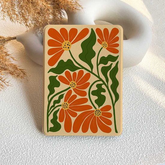 A canvas Kindle case featuring a floral pattern with orange flowers and green leaves, displayed on a neutral background.