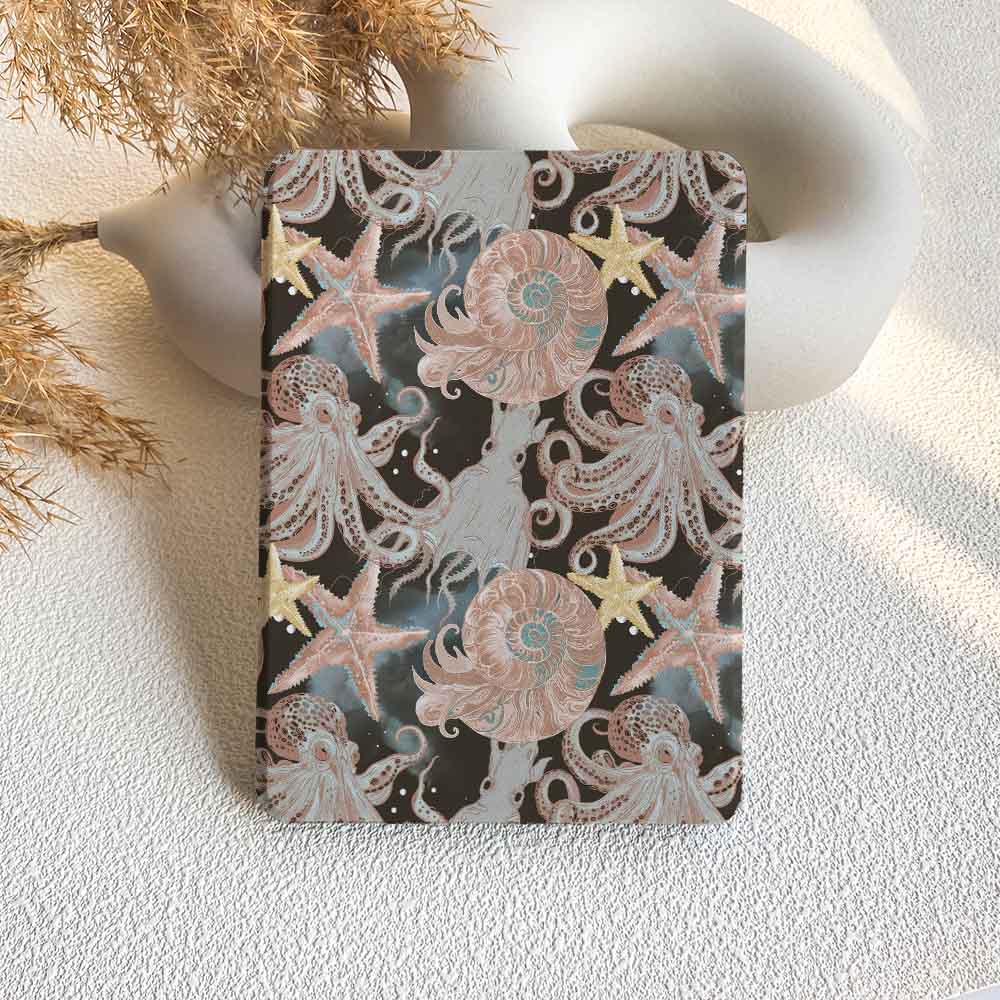 Notebook with ocean-themed design featuring stars, octopuses, and ammonites on a textured surface.