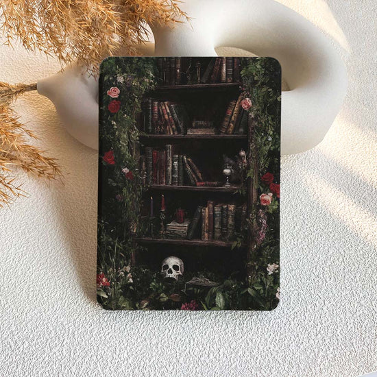 Decorative metal tin with a bookshelf design featuring books, flowers, and a skull on a textured white surface.