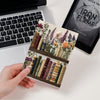 Decorative bookend with floral and book design on a desk with laptop and tablet.
