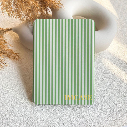 Green and white striped notebook on a textured surface with dried plants