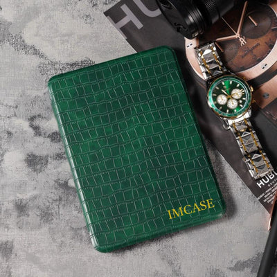 Green textured IMCASE case on a gray surface with a watch and camera.