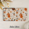 Kobo Libra e-reader with a Halloween-themed case on a textured surface.