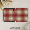 Red and white checkered case for Kobo Libra on a textured surface with flowers.