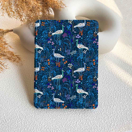 Notebook with a blue floral and bird pattern on a textured surface.