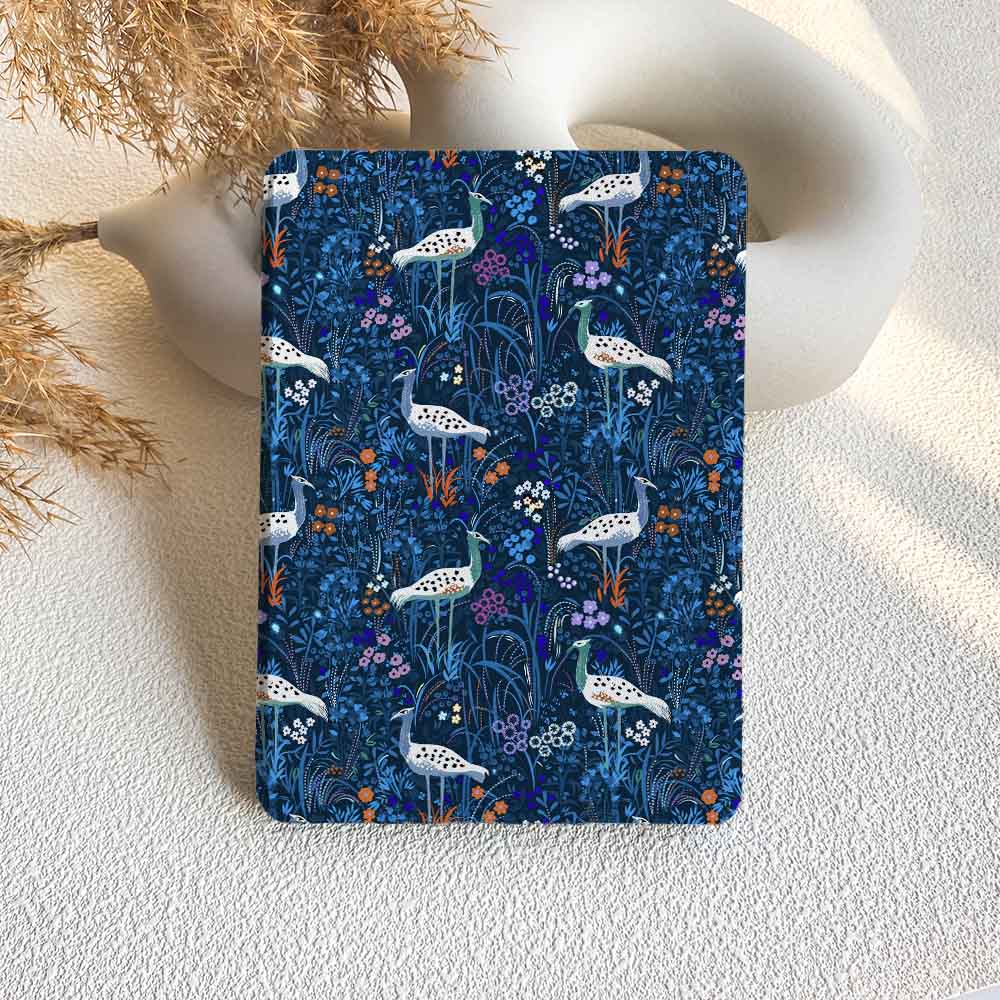 Notebook with a blue floral and bird pattern on a textured surface.