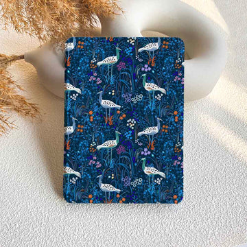 Notebook with a blue floral and bird pattern on a textured surface.