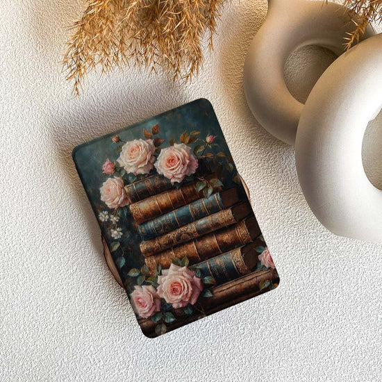 kindle case with vintage books and roses design on a textured surface.