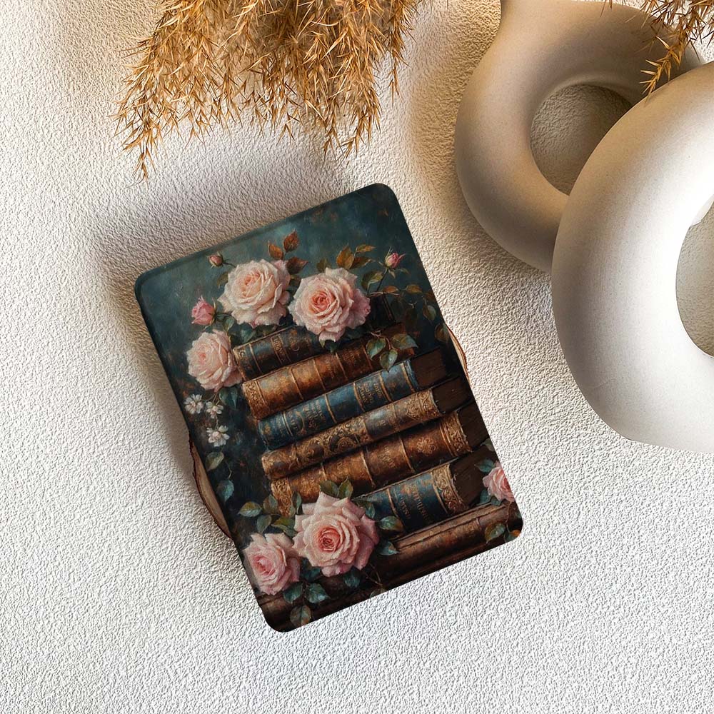 kindle case with vintage books and roses design on a textured surface.