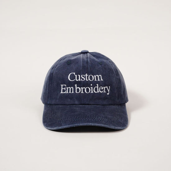 Navy blue cap with 'Custom Embroidery' text on a light gray background