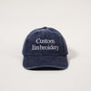 Navy blue cap with 'Custom Embroidery' text on a light gray background